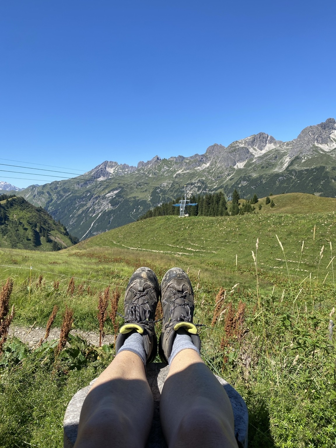 Blick über Bergwiese und Wanderschuhe